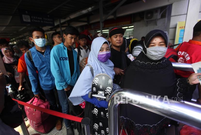 Railway passengers queue at Pasar Senen Station, Jakarta, on December 27, 2017.