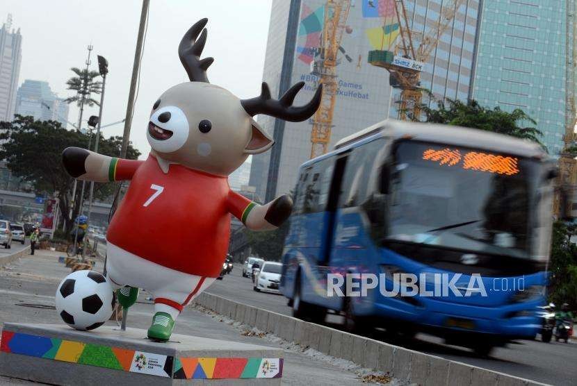 Sejumlah kendaraan melintas didekat patung maskot Asian Games yang dipasang pada pembatas jalan di kawasan Sudirman, Jakarta Pusat, Kamis (2/8).