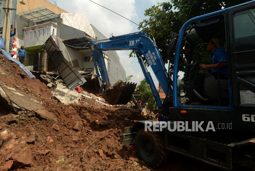 Sejumlah petugas saat membersihkan puing-puing bangunan akibat longsoran tanah yang menghancurkan satu rumah di Perumahan Pesona Kalisari, Pasar Rebo, Jakarta Timur, Selasa (27/11).