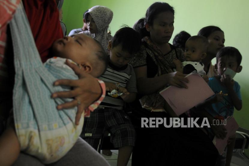 Sejumlah warga mengantre sebelum melakukan imunisasi difteri untuk anaknya di Puskemas Cimanggis, Depok, Jawa Barat, Rabu (6/12).