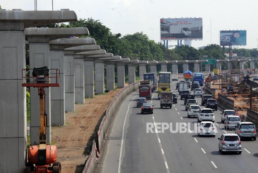 Penghentian Sementara Proyek. Sejumlah kendaraan melintas di samping lintasan jalur Light Rail Transit (LRT) di ruas tol Jakarta - Cikampek, Bekasi, Jawa Barat, Selasa (26/12).