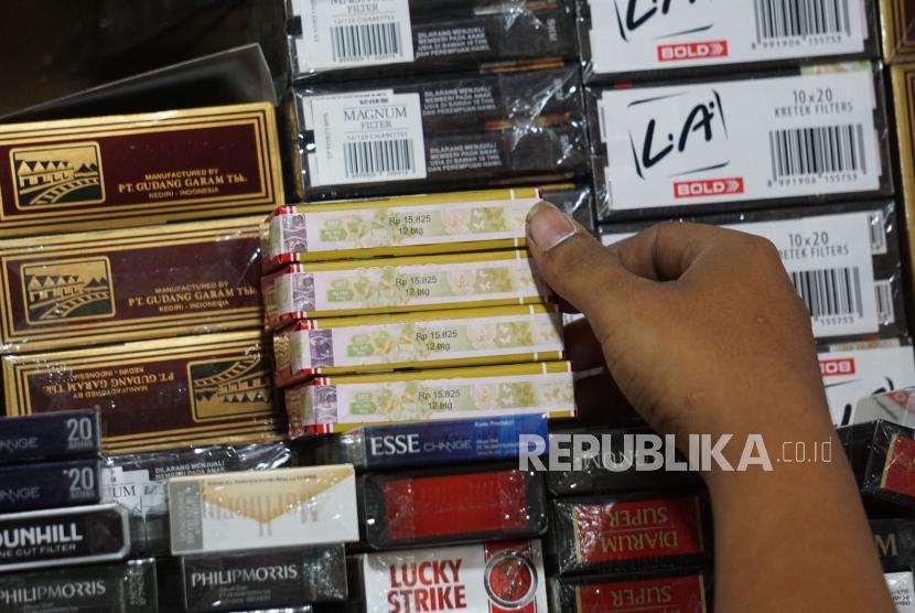 Pedagang menunjukan bungkus rokok bercukai di pasar Minggu, Jakarta, Ahad (15/9).
