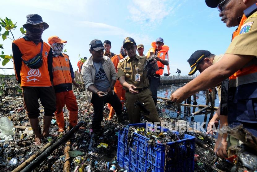 Gubernur DKI Jakarta Anies Baswedan mengambil sampah saat meninjau sampah yang menumpuk di Muara Angke, Jakarta Utara Senin (19/3).