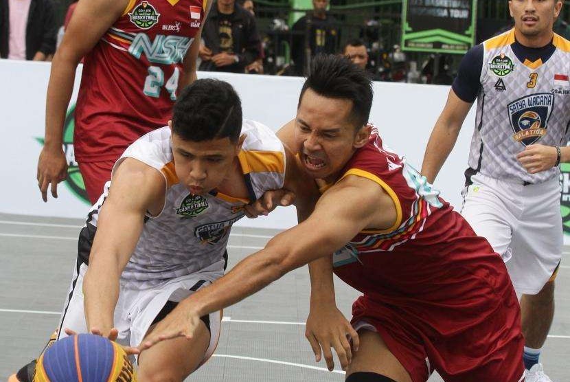 Pebasket Satyawacana Salatiga, David Liberty Nuban (kiri) berebut bola dengan pebasket NSH Jakarta, Wendra Wijaya (kanan) dalam turnamen Indonesian Basketball League (IBL) 3 X 3 GOJEK di Malang, Jawa Timur, Sabtu (21/7).