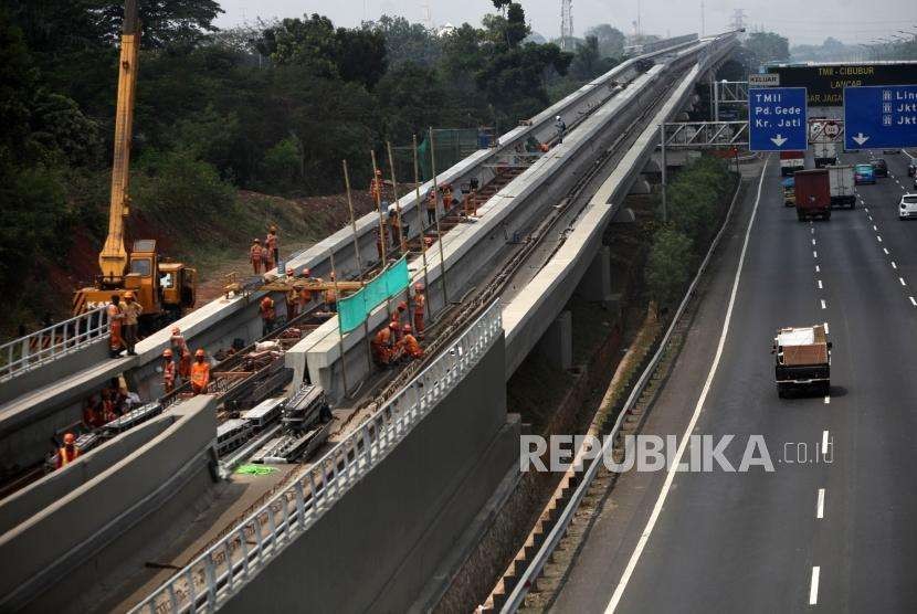 Pekerja menyelesaikan pemasangan rel Kereta Light Rail Transit (LRT) Jabodebek di kawasan Kampung Makassar, Jakarta, Selasa (28/8).