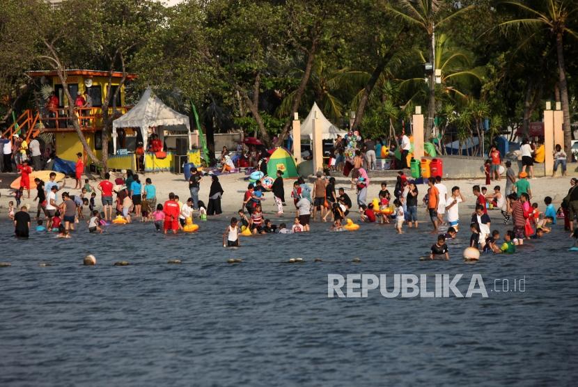 Suasana pengunjung saat liburan di Pantai Ancol, Jakarta.