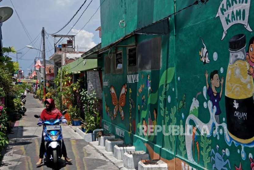 Warga dengan menggunakan sepeda motor melintas di sekitar kawasan eks lokalisasi Dolly, Surabaya, Jawa Timur. Pemkot Surabaya memastikan praktik prostitusi di bekas lokalisasi Dolly sudah tak ada.