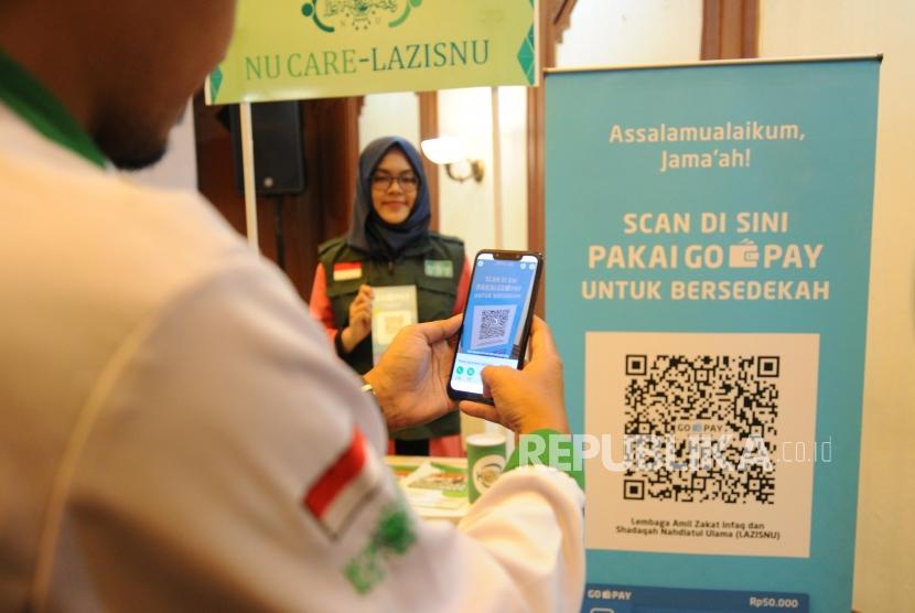 ZIS Digital Nahdliyin memindai QR Barcode untuk pembayaran zakat, infak dan sedekah secara non tunai melalui Go-Pay dalam peluncuran Kerjasama Strategis Pemberdayaan Ekonomi Umat berbasis Digital antara Gojek, Go-Pay dengan NU Care LazisNU di Jakarta, Selasa (16/7).