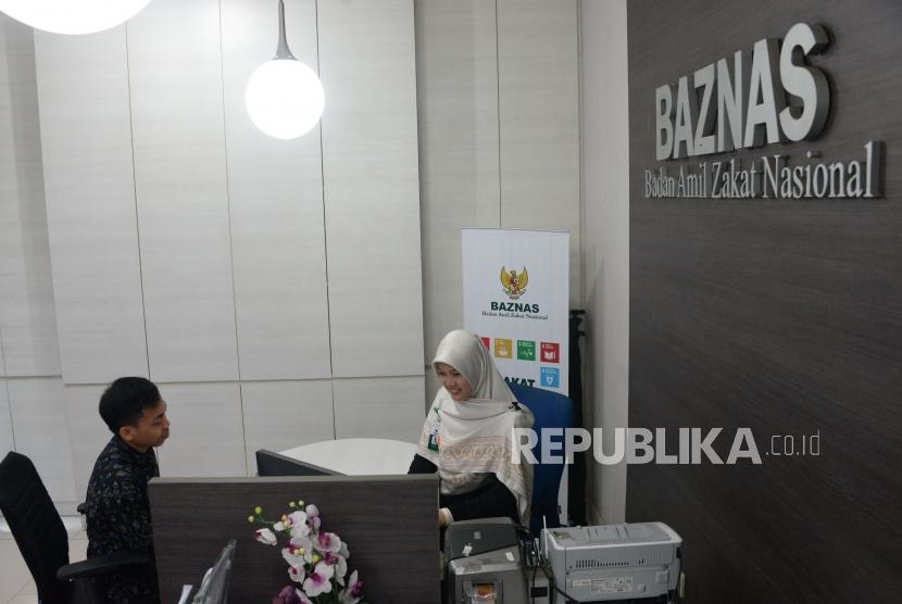 Petugas amil melayani muzaki di counter layanan muzaki Badan Amil Zakat Nasional (Baznas), Jakarta, Rabu (2/1).