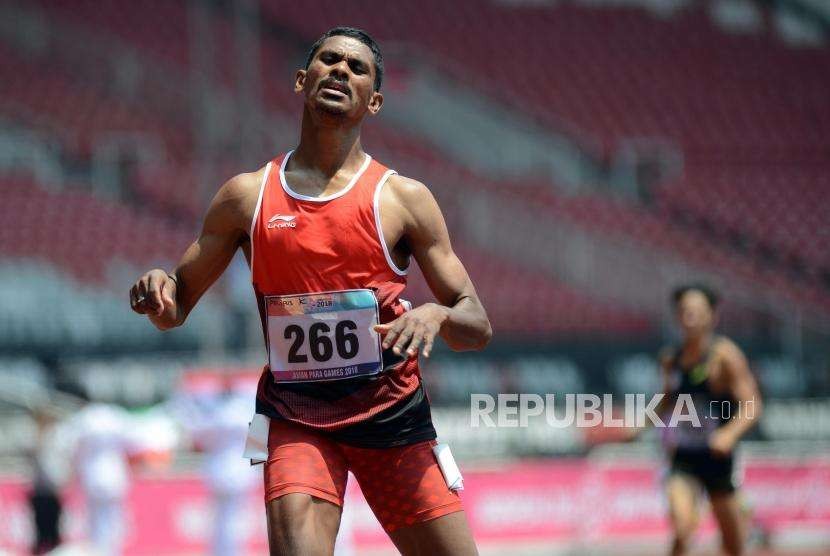 Atlet lari Indonesia Felipus Kolymau (kiri) saat tiba di garis finish pada babak final para atletik nomor lari 400 meter putra T20 Asian Para Games 2018 di Stadion Utama Gelora Bung Karno, Jakarta, Selasa (9/10).