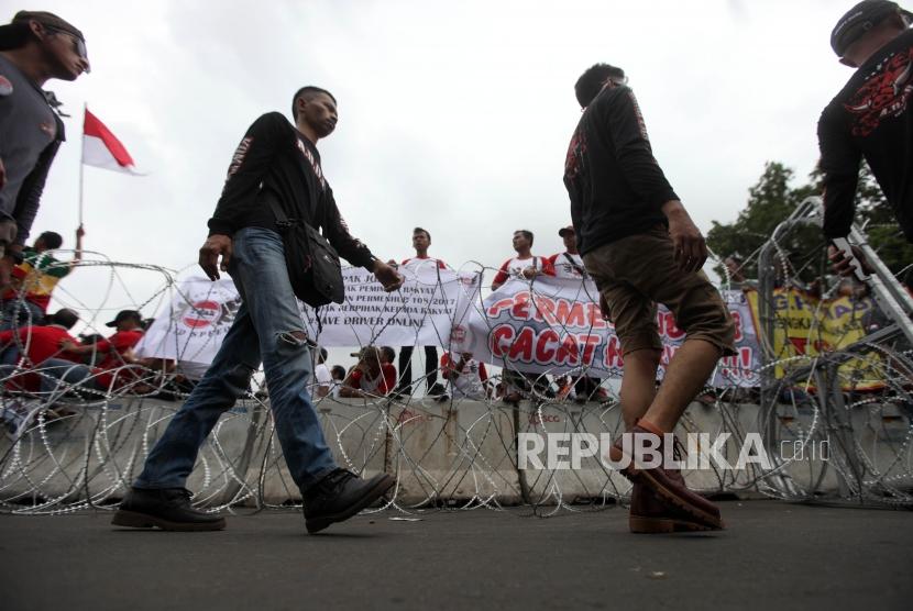 Massa pengemudi taksi online melakukan aksi unjuk rasa di depan Istana Negara, Jakarta, Rabu (14/2).