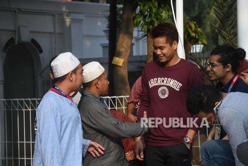 Warga bersalaman bersama atlet Indonesia Tontowi Ahmad usai melaksanakan salat Idul Adha di Masjid Al-Bina komplek Gelora Bung Karno, Jakarta, Rabu (22/8).