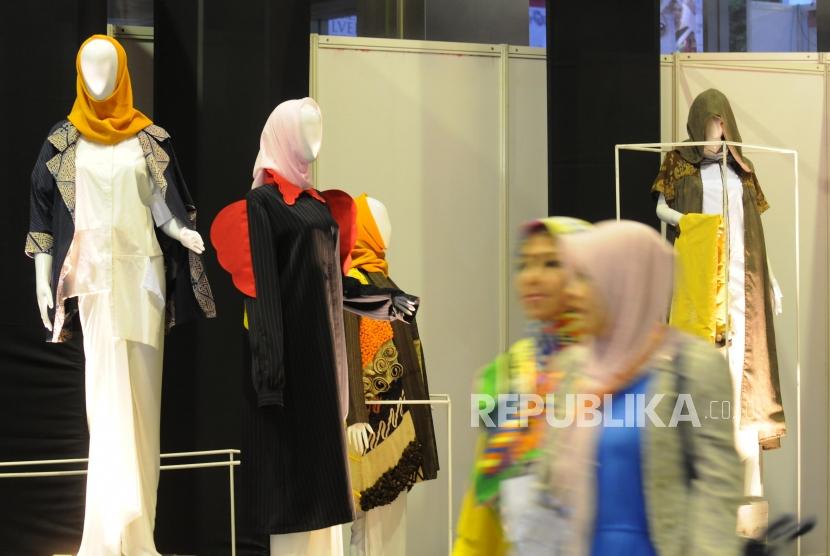 Pengunjung melintas di depan stan yang tersedia pada acara Muslim Fashion Festival 2018 di Jakarta Convention Center. Pelaku usaha industri fashion Muslim mengaku mengalami penurunan penjualan secara drastis akibat pandemi Covid-19.