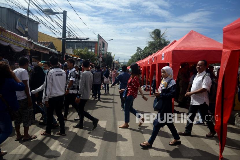 Pejalan kaki melintas diantara tenda yang akan digunakan pedagang ketika dilakukanya penutupan Jalan Jatibaru di Kawasan Tanah Abang, Jakarta, Jumat (22/12).
