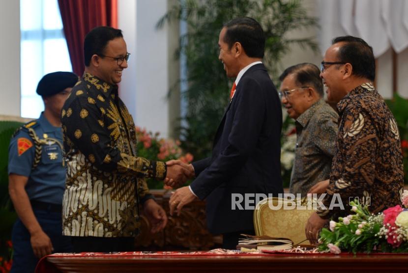 Presiden Joko Widodo berjabat tangan dengan Gubernur DKI Jakarta Anies Baswedan seusai mengumumkan pemindahan ibukota negara di Istana Merdeka, Jakarta, Senin (26/8).