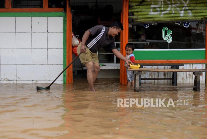 Warga beraktivitas saat banjir melanda ruas jalan Jatinegara Barat, Jakarta, Selasa(6/2).