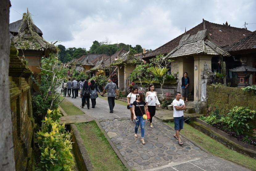 Sejumlah wisatawan mengunjungi Desa Adat Penglipuran di Kubu, Kabupaten Bangli, Bali, Kamis (19/7).