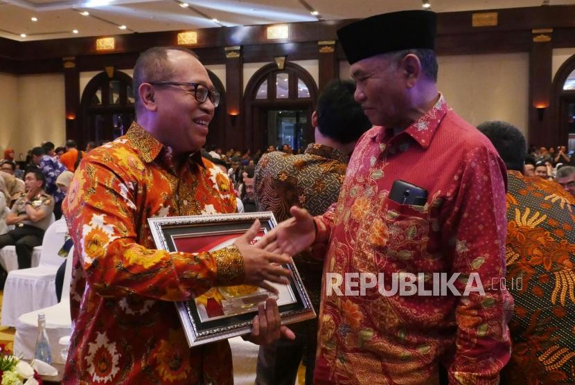Ketua KPK Agus Rahardjo (kanan) memberikan ucapan selamat kepada Direktur Utama BPJS Ketenagakarjaan Agus Susanto usai menerima penghargaan pada acara peringatan Hari Anti Korupsi Sedunia 2017 di Jakarta, Selasa (12/12).