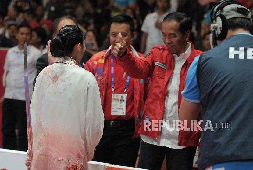 Presiden Joko Widodo memberikan salam kepada atlet wushu Indonesia Lindswell Kwok usai bertanding di cabang wushu nomor taijijian Asian Games 2018 di Kemayoran, Jakarta, Senin (20/8).