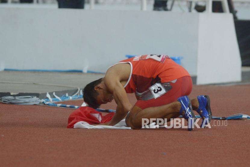 Sprinter Indonesia Sapto Yogo Purnomo bersujud usai menjuarai final 100 meter putra T37 Asian Para Games di Stadion Utama Gelora Bung Karno, Senayan, Jakarta, Selasa  (9/10).