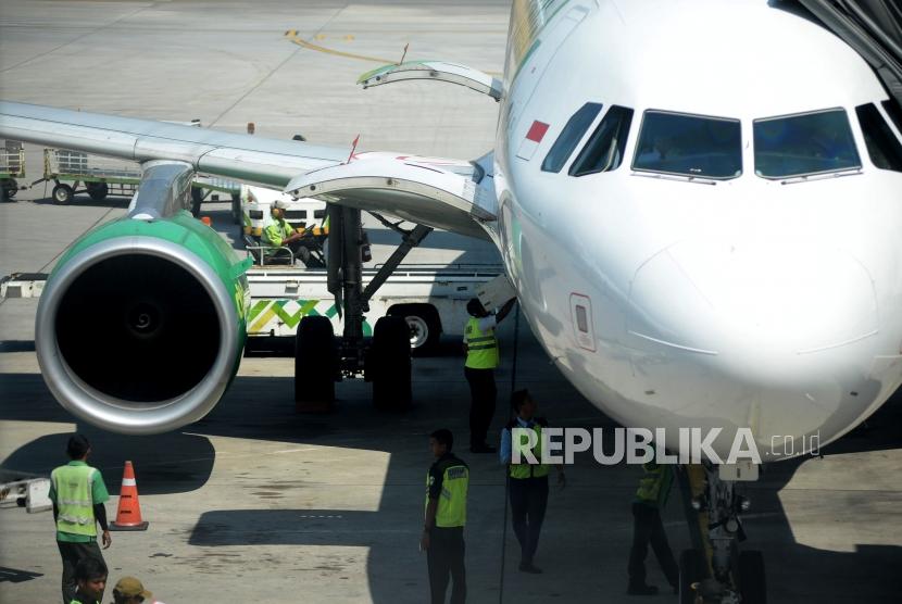 Petugas menurunkan bagasi milik penumpang pesawat di Bandara Internasional Ahmad Yani,Semarang,Jawa Tengah,Rabu (10/7).