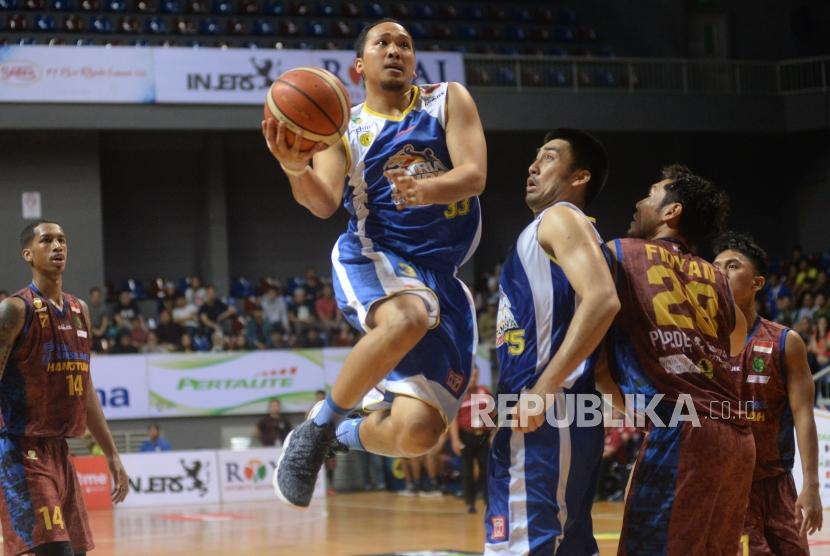 Pebasket Satria Muda Pertamina Arki Dikania Wisnu berusaha melewati hadangan pemain BSB Hangtuah pada semifinal game ketiga IBL di Britama Arena, Jakarta, Ahad (25/3).