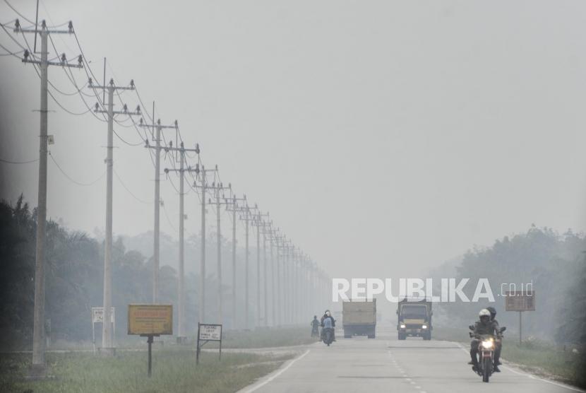 Sejumlah kendaraan melintas saat kabut asap kebakaran hutan dan lahan menyelimuti Kota Pekanbaru, Riau, Selasa (10/9).