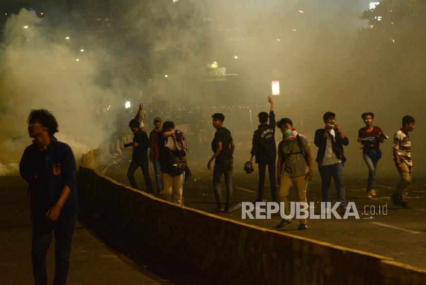 Massa Aksi Mahasiswa Indonesia berlari menghindari gas air mata saat aksi di depan kawasan Jalan Tol Dalam Kota Gatoto Soebroto, Jakarta, Selasa (24/9/2019).