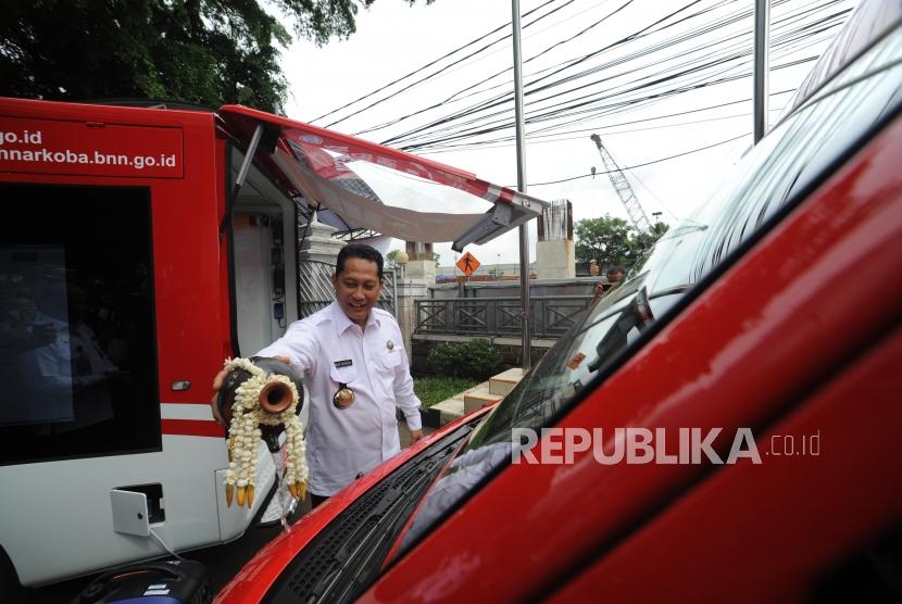 Kepala BNN Komjen Pol Budi Waseso menyiram air ke mobil pencegahan BNN  dalam peluncuran mobil di Kantor BNN, Jakarta, Rabu (27/12).