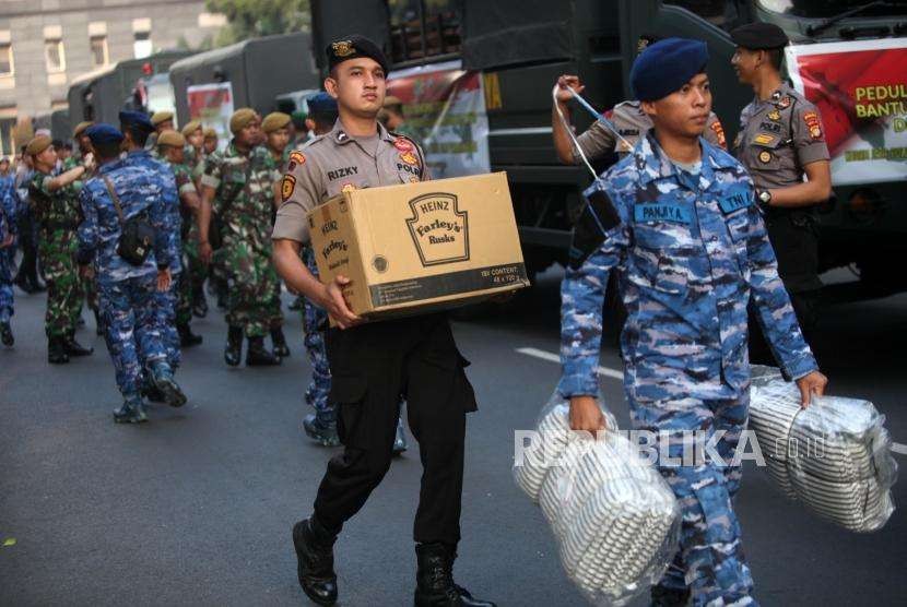 Petugas mengangkut bantuan logistik untuk pengiriman bantuan kemanusian di Mapolda Metro Jaya, Jakarta