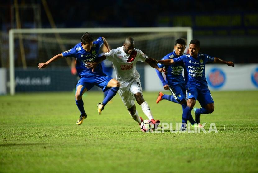 Striker PSM Makassar Djite Bruce Jose diadang tiga pemain Persib Bandung pada pertandingan Grup A Piala Presiden 2018 di Stadion Gelora Bandung Lautan Api Bandung, Jumat (26/1).