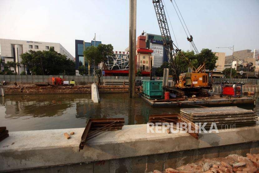 Pekerja dari Dinas Sumber Daya Air Pemerintah Provinsi (Pemprov) DKI Jakarta mengoprasikan alat berat saat memasang turap di Kali Ciliwung lama, Jalan Veteran, Jakarta, Rabu (10/10).