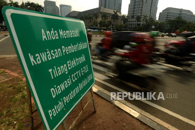 Pengendara motor melintas didekat plang sosialisasi kawasan pemberlakuan tilang elektronik di Jalan MH Thamrin, Jakarta, Jumat (30/11).