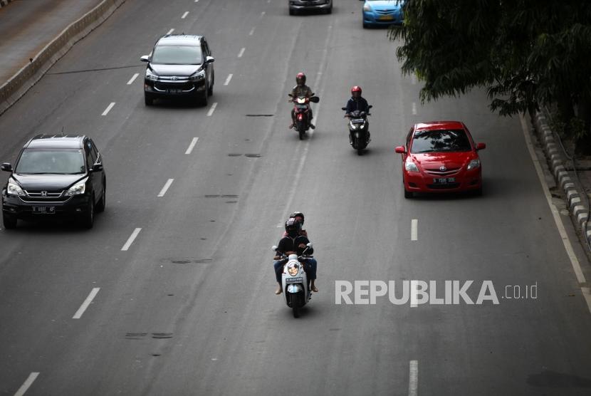 Pengendara motor melintas di ruas Jalan MH, Thamrin, Jakarta, Selasa ( 9/1).