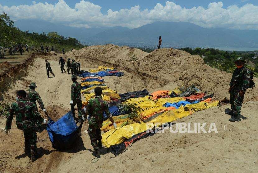 Sejumlah Prajurit TNI melakukan penguburan massal terhadap jenazah korban gempa bumi dan tsunami di Taman Pemakaman Umum (TPU) Poboya Indah, Palu, Sulawesi Tengah, Selasa (2/10).