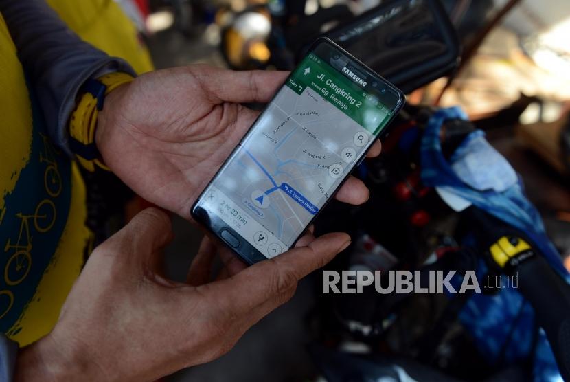 Pelancong pengguna sepeda menggunakan GPS sebagai peta digital untuk melihat lokasi tujuan.