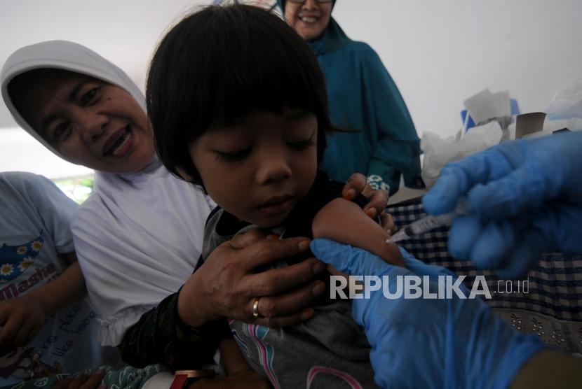 Imunisasi Massal Difteri. Seorang balita saat disuntik imunisasi Difteri di Posyandu Mawar, Pancoran Mas, Kota Depok, Jawa Barat, Senin (11/12).