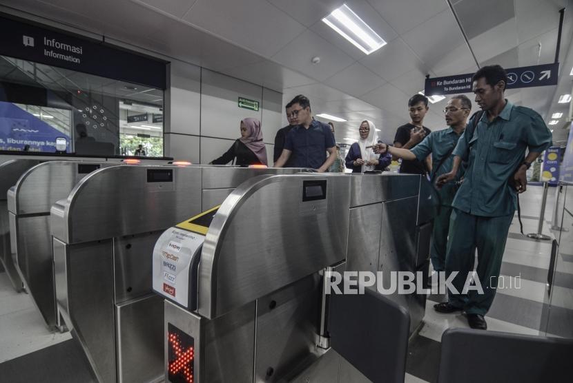 Sejumlah masyarakat melakukan tapping kartu untuk menaiki MRT (Mass Rapid Transit)  di stasiun Lebak Bulus, Jakarta Selatan