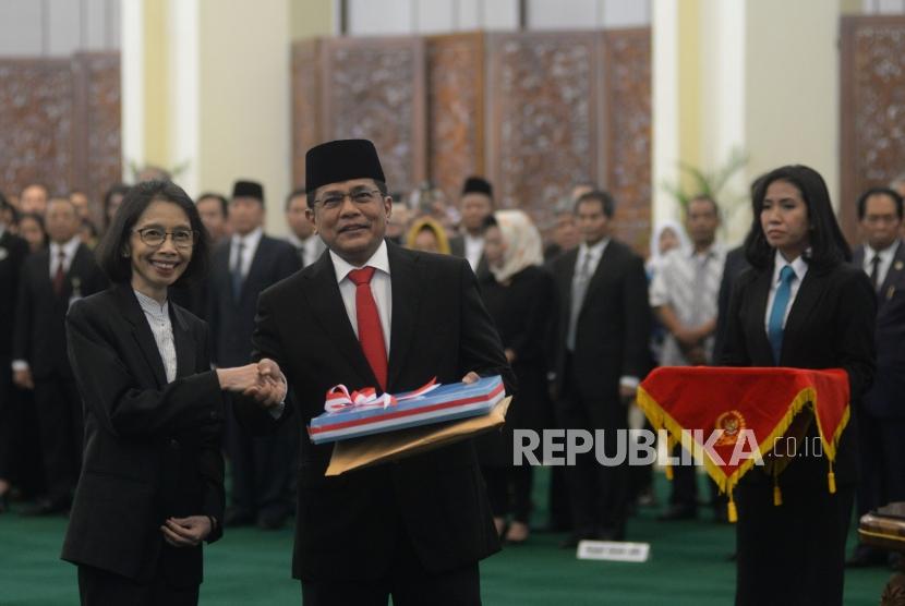 Sekjen DPR RI yang baru Indra Iskandar (kedua kiri) berjabat tangan dengan pejabat lama Plt Sekjen DPR RI Damayanti (kiri) pada acara pelantikan sekjen DPR di Gedung Nusantara IV, Kompleks Parlemen, Senayan, Jakarta, Selasa (22/5).