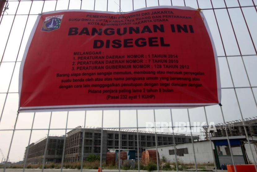 Spanduk penyegelan terlihat disalah satu bangunan di Proyek Reklamasi Pulau D, Teluk Jakarta, Kamis (7/6).