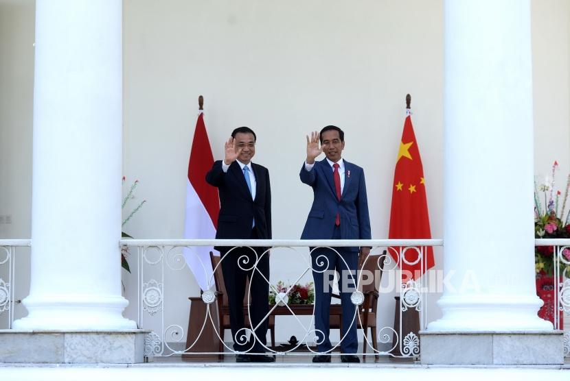 Terima Kunjungan PM RRT. Presiden Joko Widodo (kanan) bersama Perdana Menteri Cina Li Keqiang melambaikan tangan kepada jurnalis di Beranda Istana Bogor, Jawa Barat, Senin (7/5).