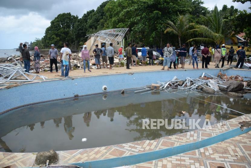 Warga menyaksikan dampak kerusakan akibat bencana Tsunami di Pantai Carita, Banten, Senin (24/12).