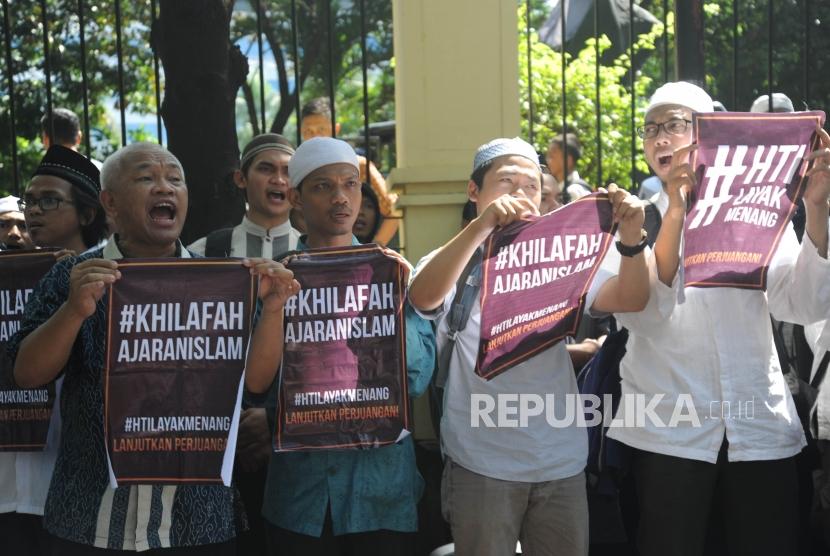 Massa HTI memegang spanduk usai  mengetahui  hasil sidang pembacaan putusan gugatan Hizbut Tahrir Indonesia (HTI) di Pengadilan Tata Usaha Negara (PTUN), Jakarta, Senin (7/5).