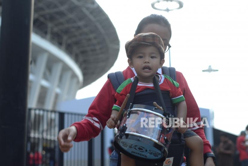 penonton  Piala AFC U19  membawa anak kecil untuk menyaksikan pertandingan sepakbola di   Stadion Utama Gelora Bung Karno, Jakarta, Ahad (28/10).