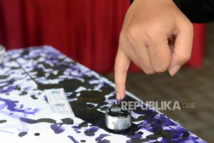 Sejumlah warga mencelupkan tinta ke jarinya di tempat pemungutan suara (TPS) bertemakan Kampoeng Pemilu Nusantara di Depok, Jawa Barat, Rabu (17/4).