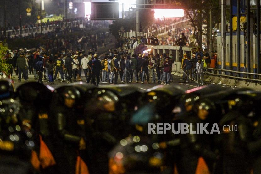Sejumlah mahasiswa berhadapan dengan polisi saat terjadi kericuhan di depan Gedung DPR, Jakarta, Selasa (24/9).