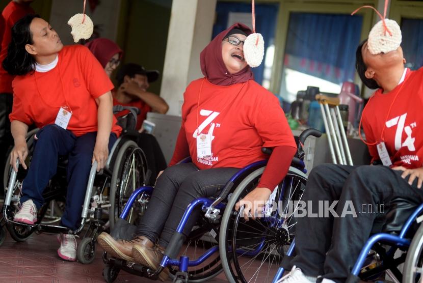 Penyandang disabilitas mengikuti lomba makan kerupuk pada perayaan hari Kemerdekaan Indonesia ke-74 di Wisma Cheshire, Cilandak,  Jakarta , Sabtu (17/8).