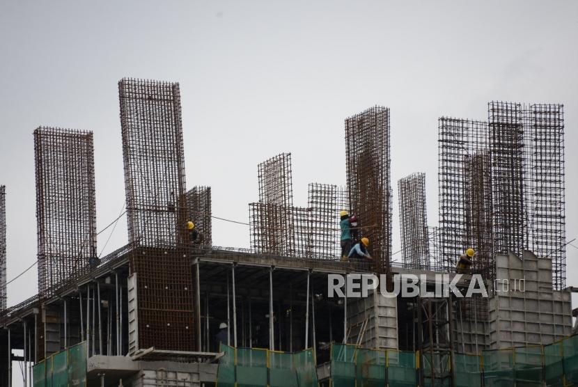 Pertumbuhan Ekonomi. Pekerja beraktivitas pada proyek pembangunan gedung bertingkat di Jakarta, Selasa (12/3).