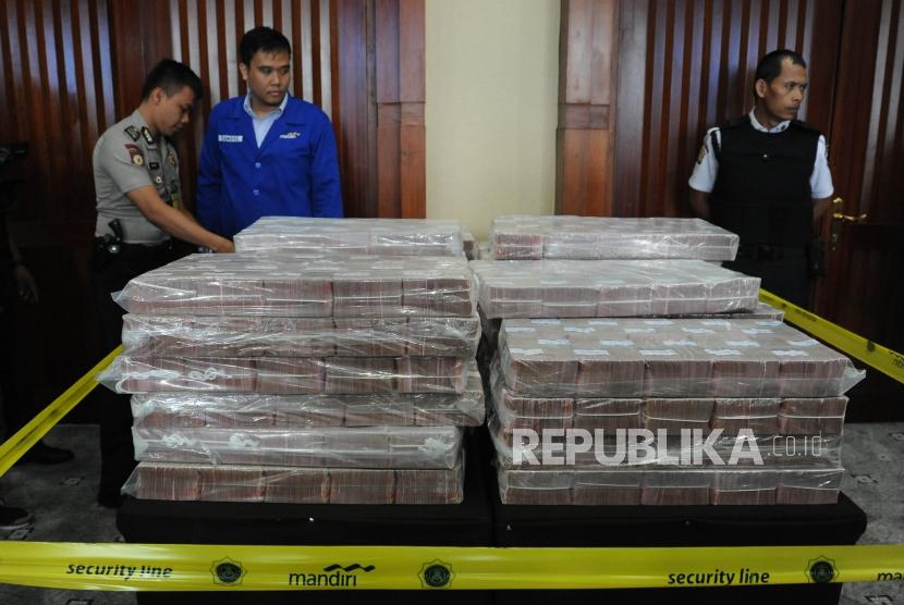 Pegawai Bank Mandiri dan kepolisian  memasang garis pembatas saat penyerahan  uang ganti rugi korupsi Bantuan Likuidasi Bank Indonesia (BLBI) dengan terpidana Samadikun Hartono di Gedung Bank Mandiri, Jakarta, Kamis (17/5).