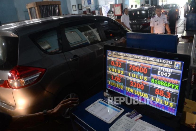 Petugas memeriksa mobil taksi daring saat uji kir di Unit Pengelola Pengujian Kendaraan Bermotor (UP-PKB) Pulogadung, Jakarta, Ahad (5/11).